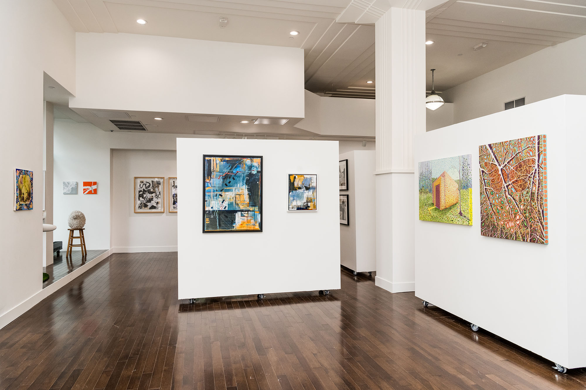 Interior photograph of an exhibition space with paintings and sculptures